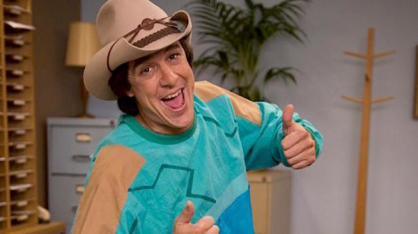 Samuel Johnson as Molly Meldrum thumbs up green jumper