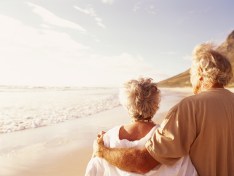 thinkstock_Senior couple embracing on beach, rear view
