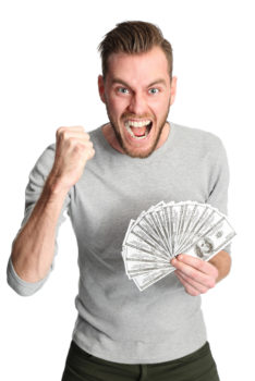 Attractive man wearing a shirt, holding a fan of dollar bills in front of him. White background.
