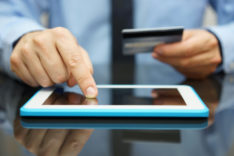 businessman is buying goods on tablet computer with credit card