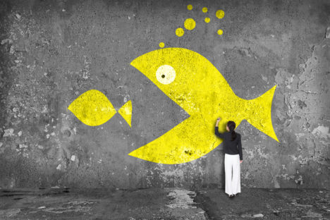 businesswoman drawing big fish on the wall