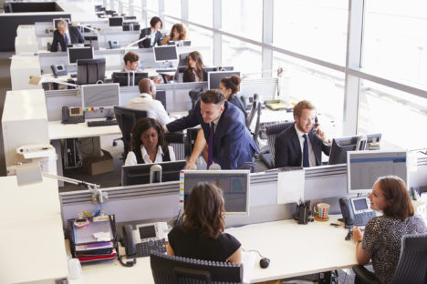 Manager in discussion with coworker in an open plan office