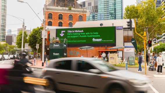Fiverr attaches freelancer to billboard to make free ads via By All Means